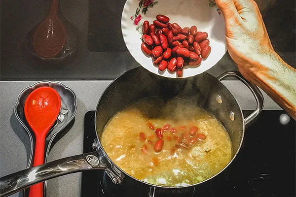 به ترکیب گوشت و پیاز لوبیا را اضافه کنید.
